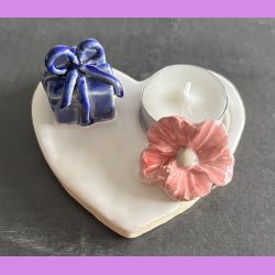 Fyrfadsholder med blomst og gave.