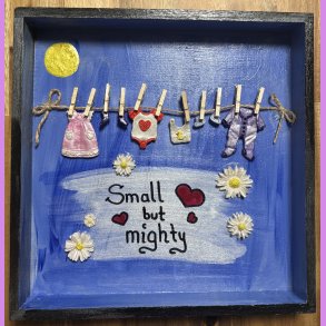 Ramme med baby t�j p� snor.